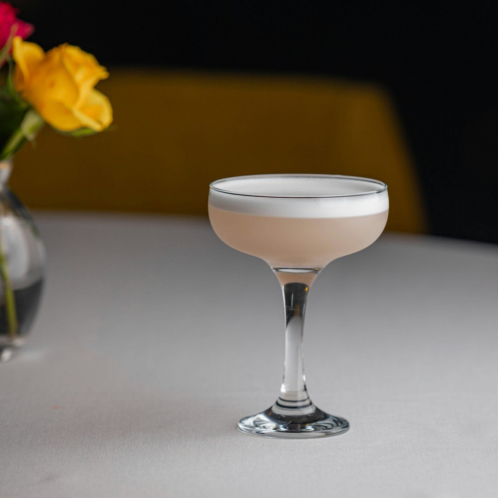 a white table topped with a glass filled with a drink