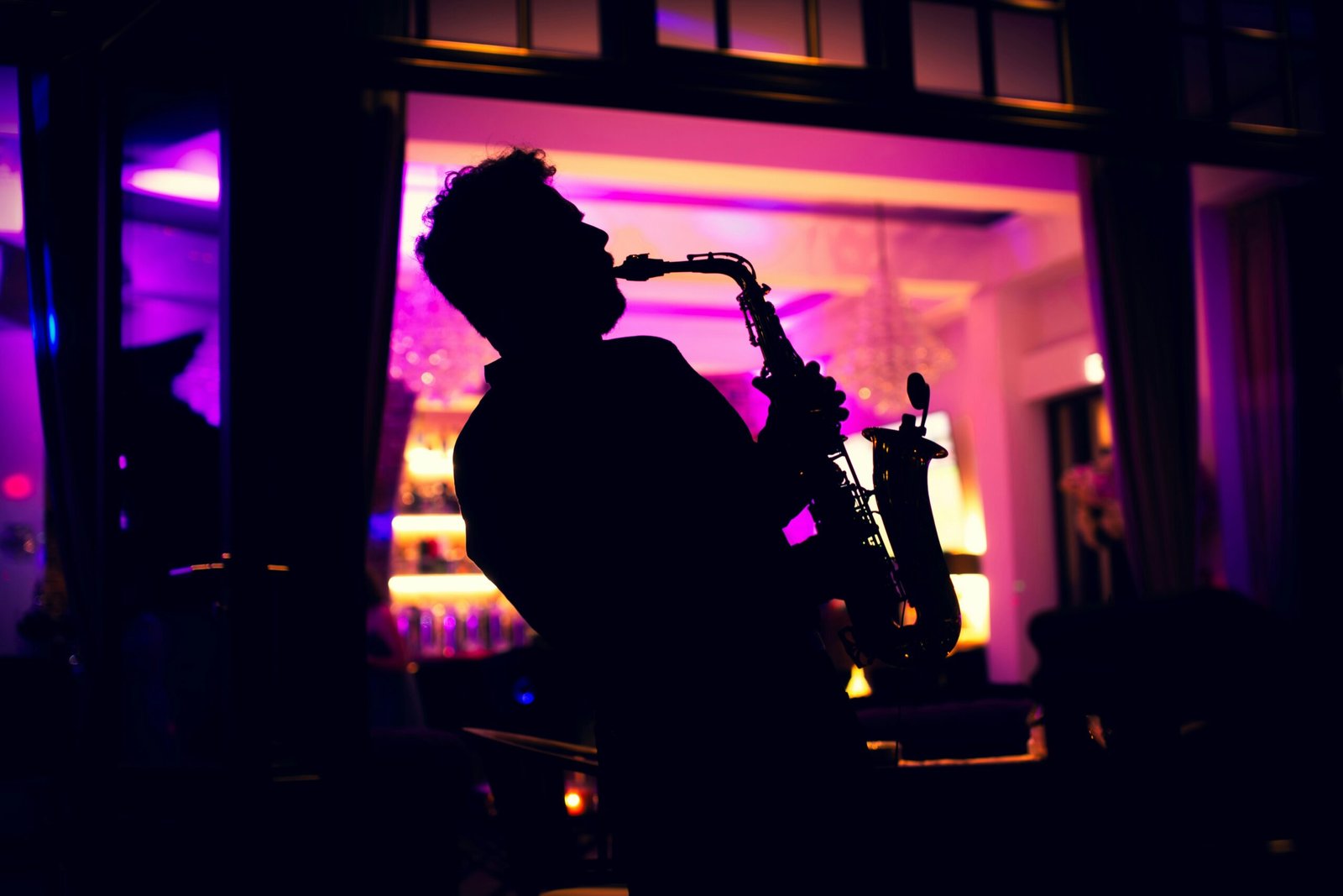 A man playing a saxophone in a dark room